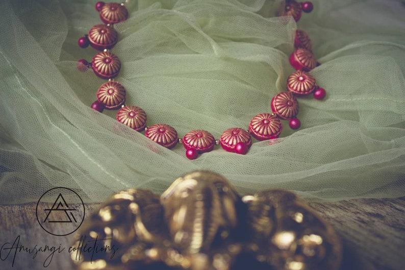 Unleash your inner goddess with our Laal Chakra Phool Necklace Terracotta Set. Handcrafted with delicate details, this necklace will add a touch of traditional charm to any outfit. The intricate design of the chakra flowers will radiate positive energy and elevate your style. 