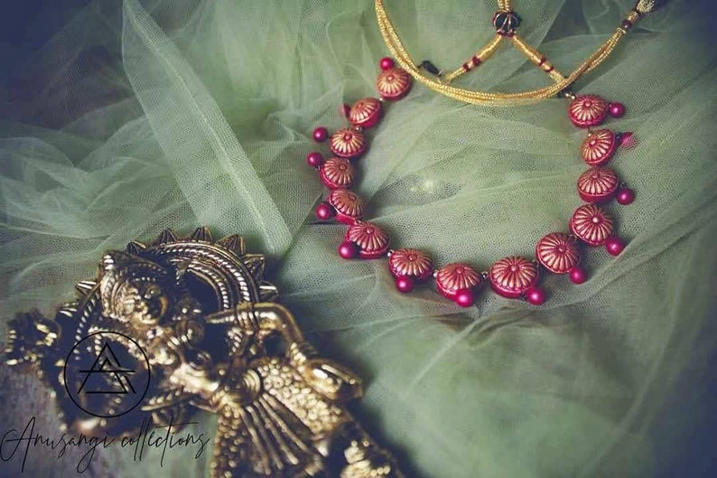 Unleash your inner goddess with our Laal Chakra Phool Necklace Terracotta Set. Handcrafted with delicate details, this necklace will add a touch of traditional charm to any outfit. The intricate design of the chakra flowers will radiate positive energy and elevate your style. 