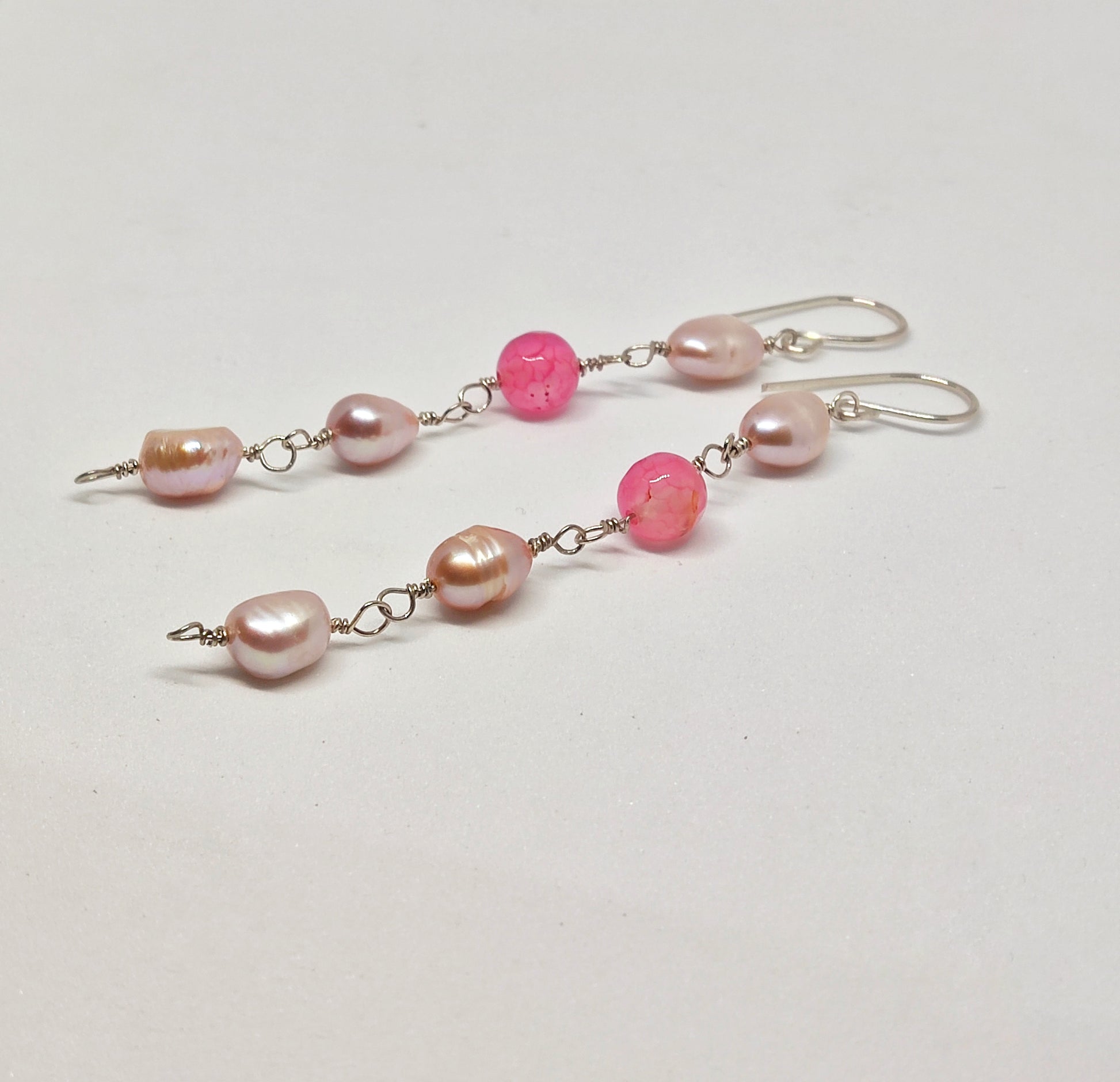 The earrings feature a striking composition of 3 pearls and 1 color of semi-precious Agate beads, creating a stand-out look that will capture attention in any crowd.