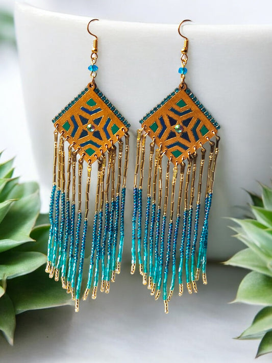 These Bella Long Beaded Earrings in blue gradience shades will add a touch of elegance to any outfit. The beautiful blue shades transition seamlessly, creating a unique and eye-catching design. Make a statement and elevate your look with these stunning earrings.