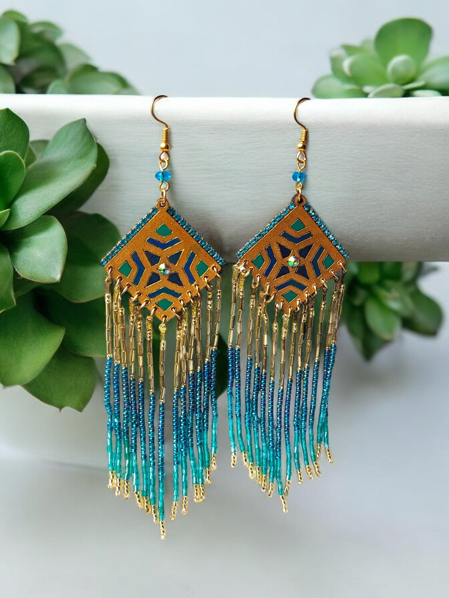 These Bella Long Beaded Earrings in blue gradience shades will add a touch of elegance to any outfit. The beautiful blue shades transition seamlessly, creating a unique and eye-catching design. Make a statement and elevate your look with these stunning earrings.