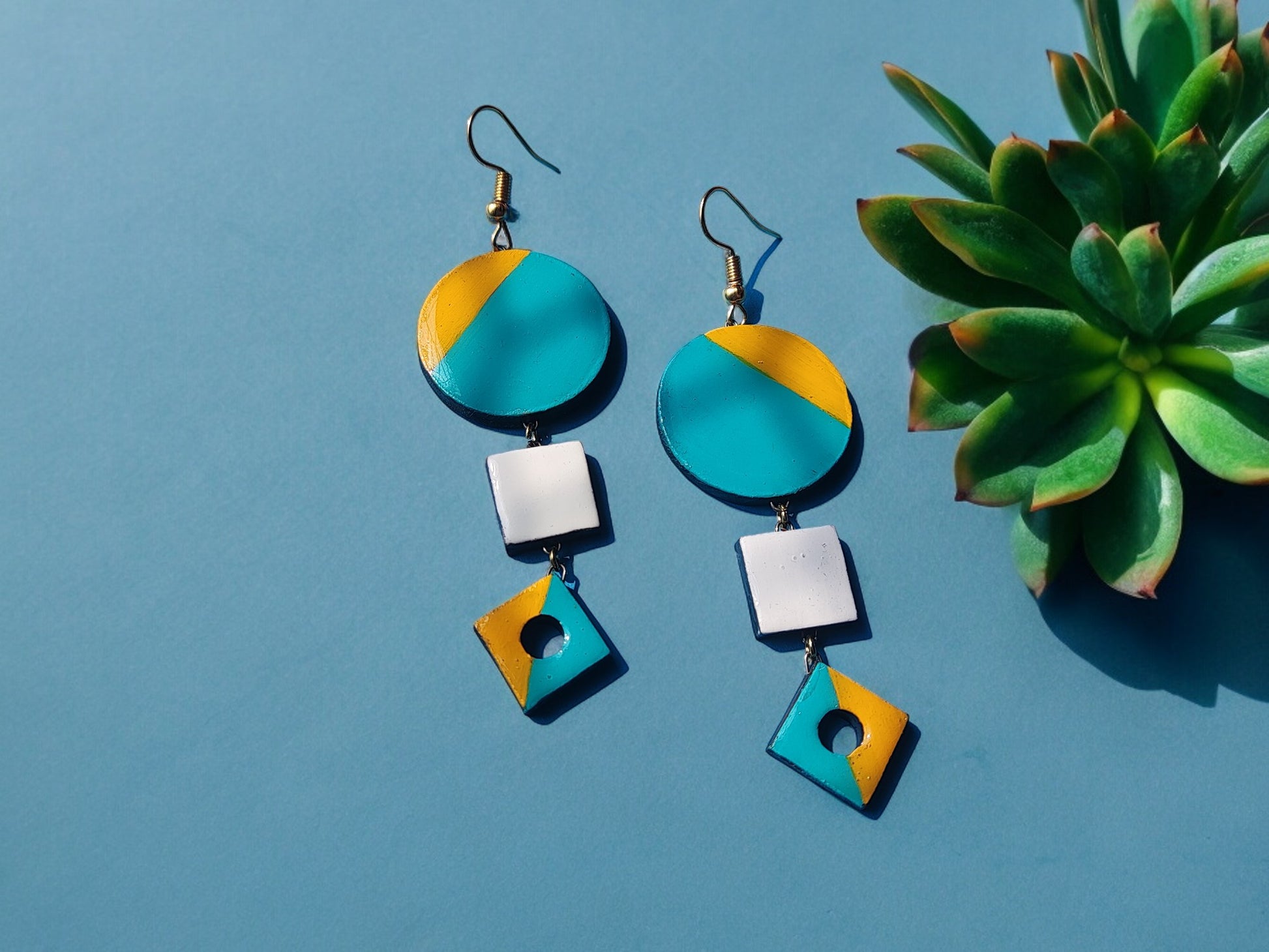 Skillfully handcrafted from terracotta, these earrings showcase a stunning color combination of yellow and teal.