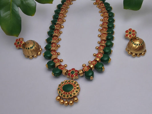 This Aadarshini Terracotta Grand Jewelry set is a must-have for any fashion-forward individual. Handcrafted from high-quality terracotta, this set boasts intricate designs and vibrant colors that are sure to make a statement. Perfect for any occasion, add a touch of elegance and culture to your wardrobe with this unique jewelry set.