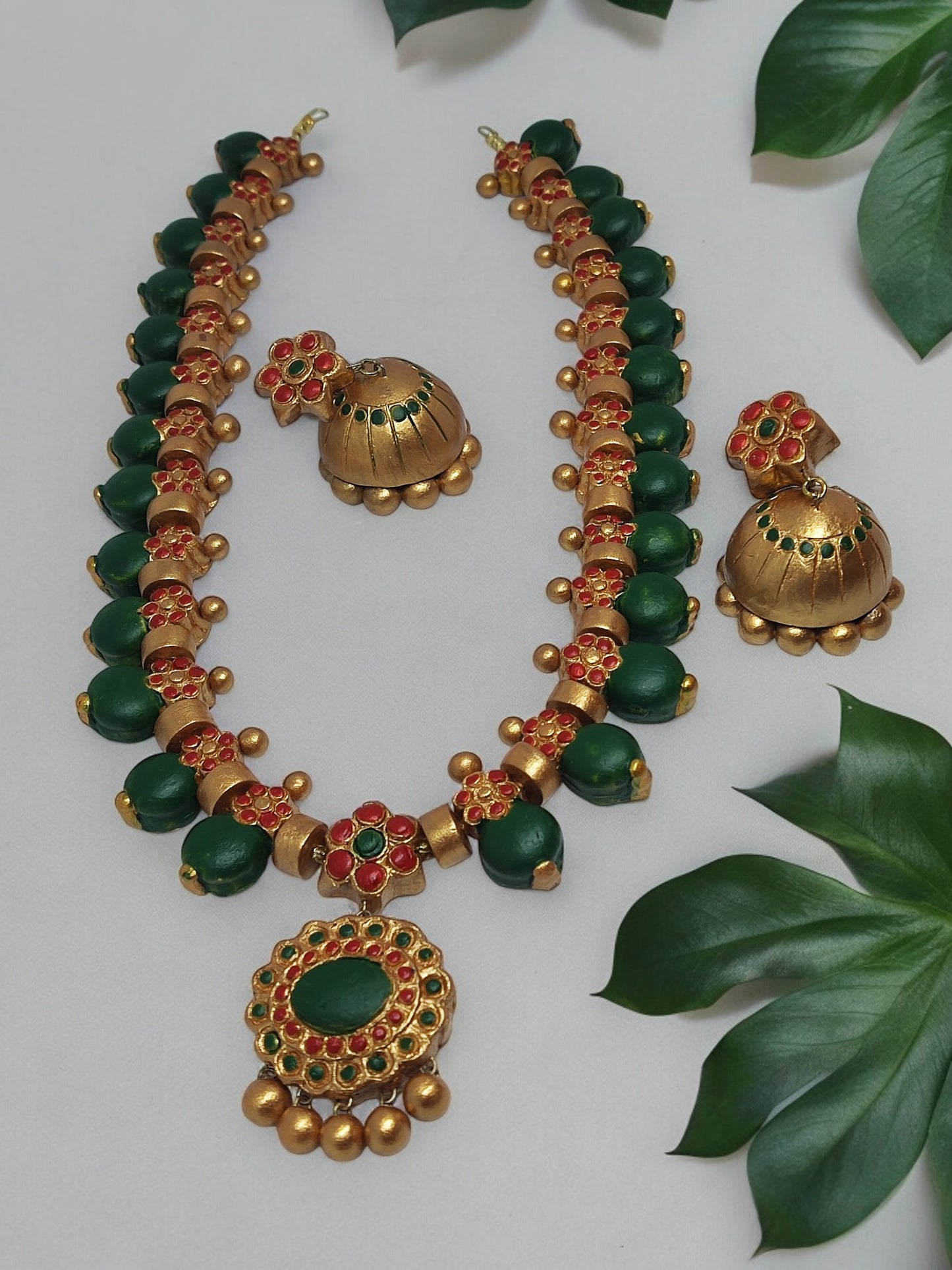 This Aadarshini Terracotta Grand Jewelry set is a must-have for any fashion-forward individual. Handcrafted from high-quality terracotta, this set boasts intricate designs and vibrant colors that are sure to make a statement. Perfect for any occasion, add a touch of elegance and culture to your wardrobe with this unique jewelry set.